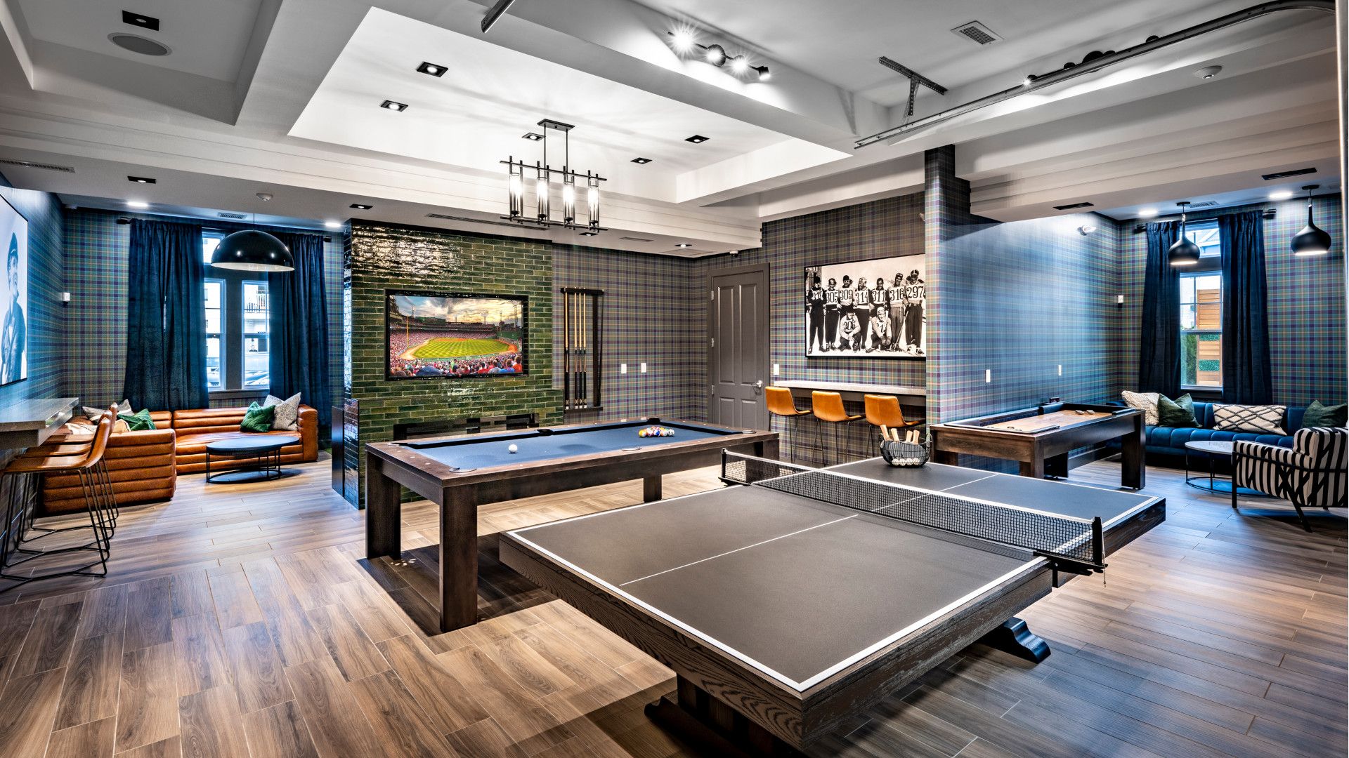 Modern game room featuring ping pong tables, seating areas, and wall art.
