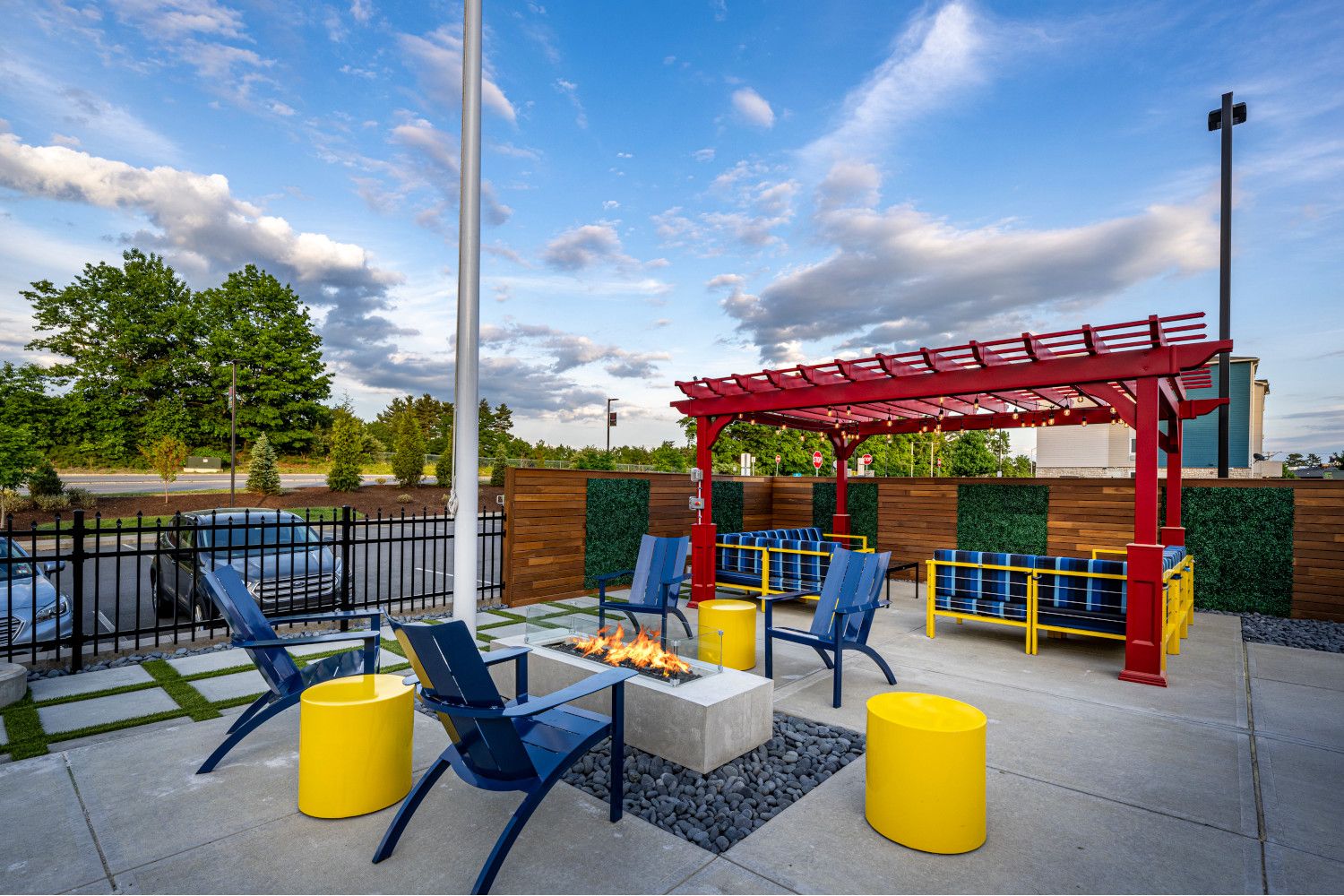 Outdoor lounge area with colorful chairs, fire pit, and shelter.