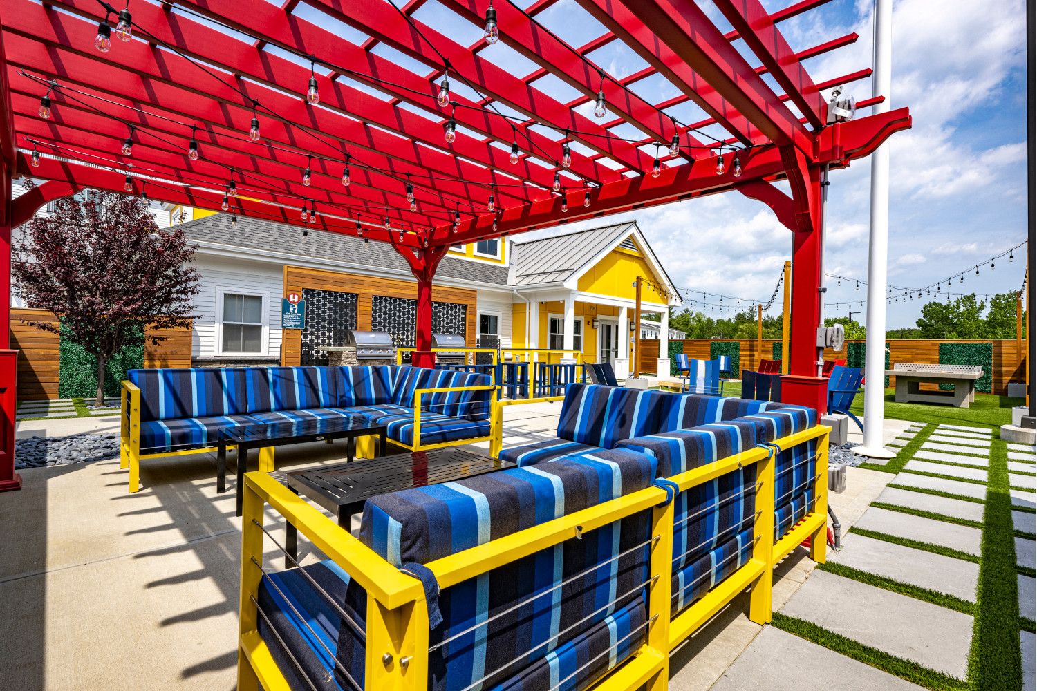 Colorful outdoor seating area with blue cushions under a red pergola.
