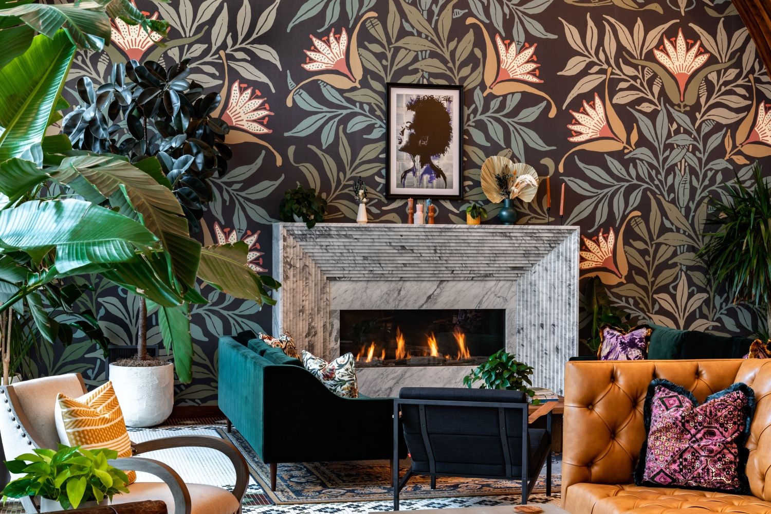 Stylish lounge with floral wallpaper, a fireplace, and colorful seating.