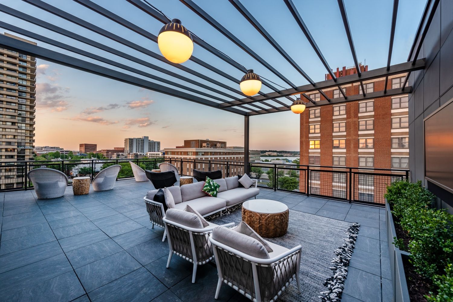 Modern rooftop lounge with seating area and sunset view.
