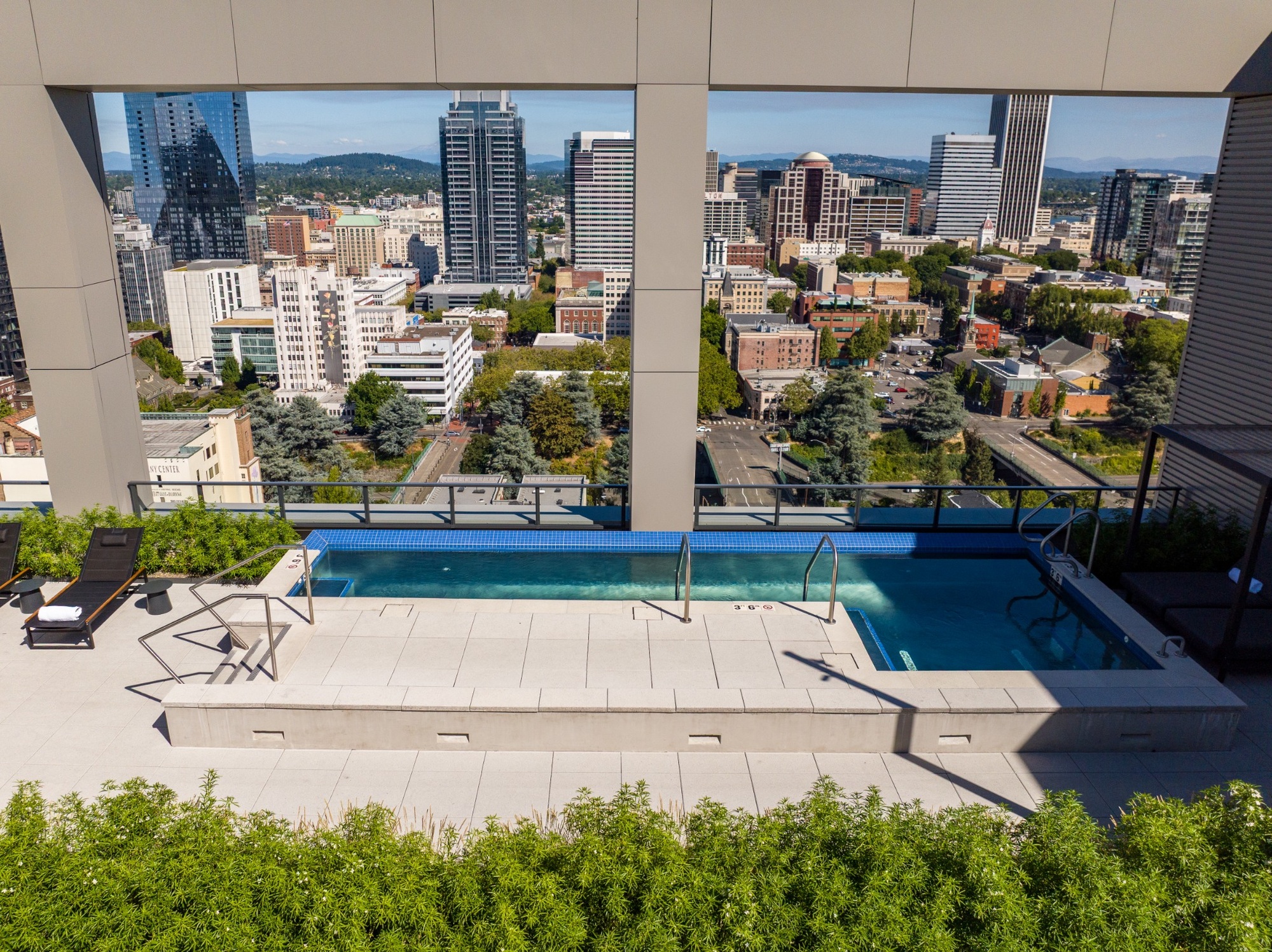 Rooftop pool and spa overlooking downtown Portland with expansive city and hillside views.