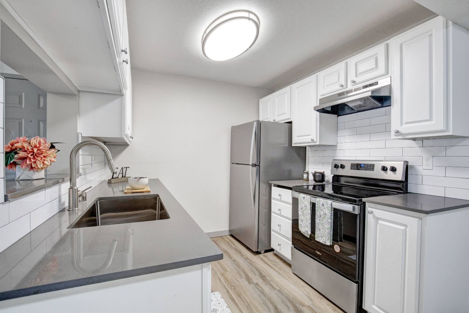 Kitchen with white cabinetry and stainless steel appliances at Taluswood Apartments.