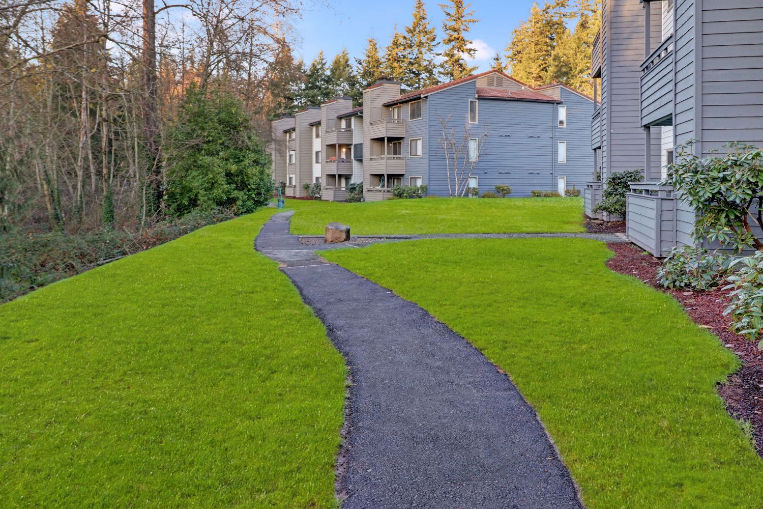 Landscaped walkway with seating area and apartment buildings
