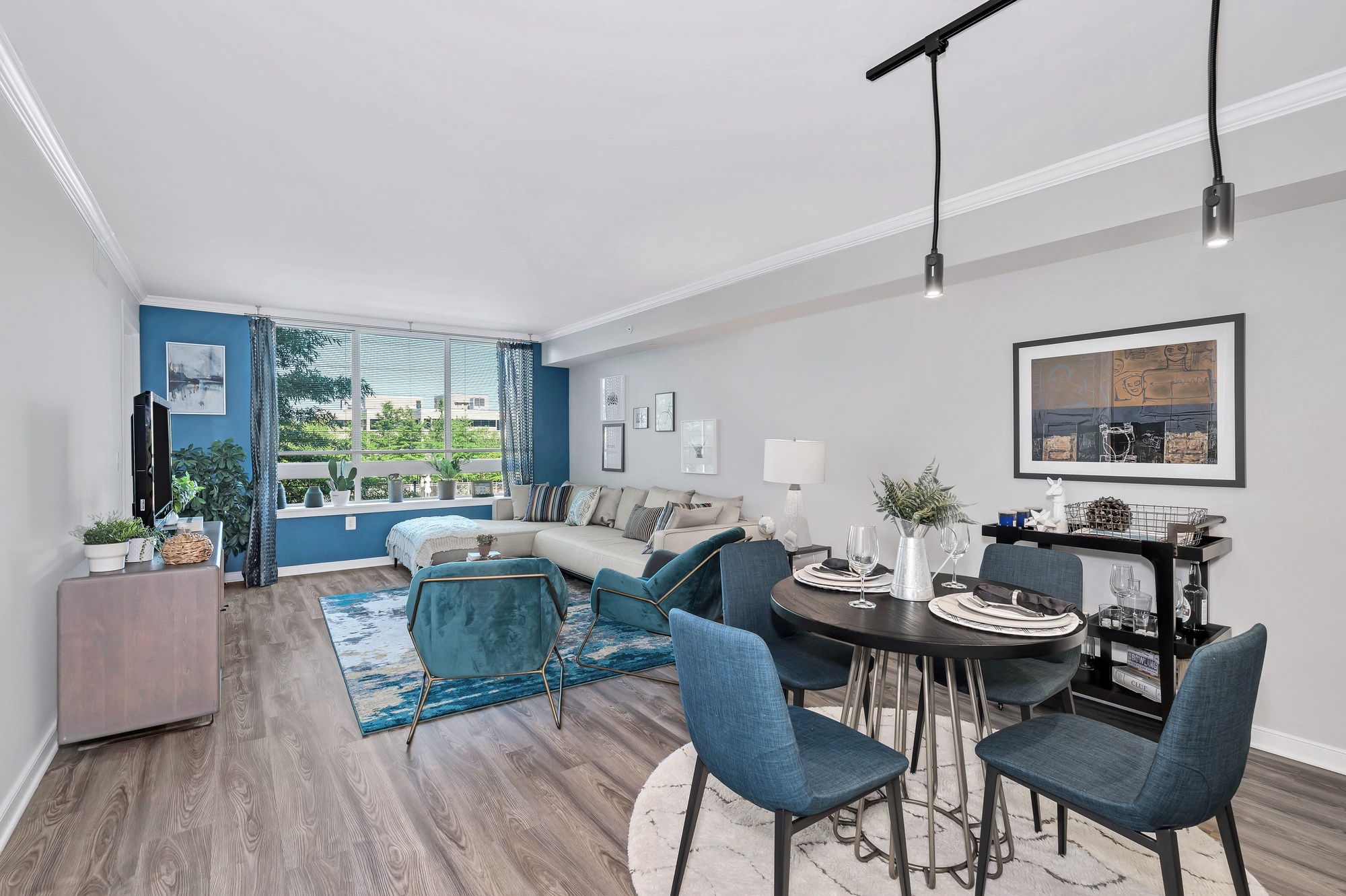 Modern living room with a dining area and large windows.