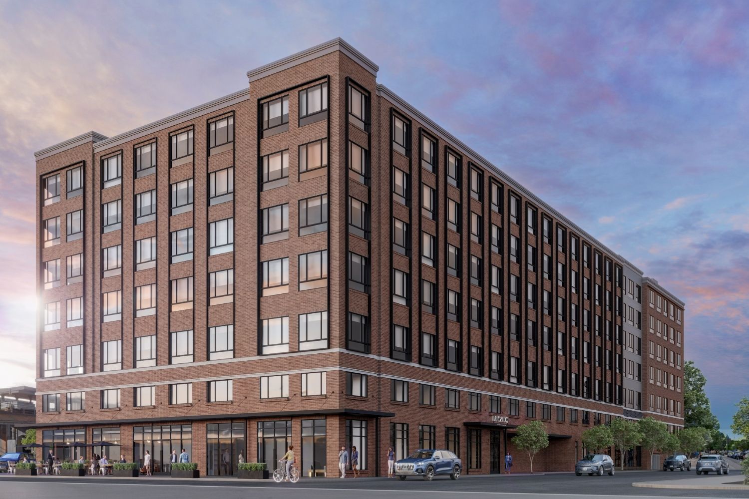 Modern multi-story brick building with large windows and a commercial ground floor.