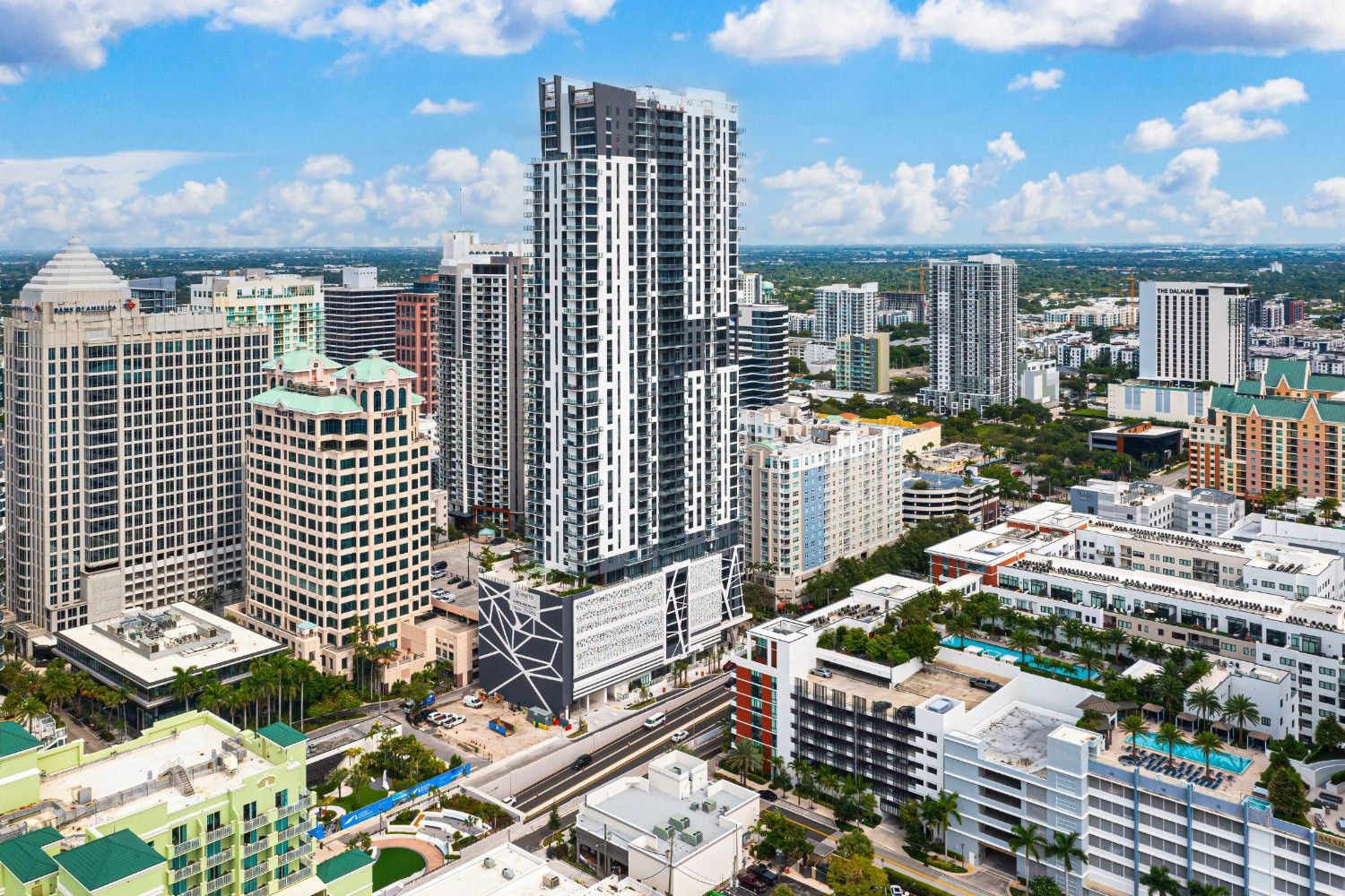 Aerial view of a modern city skyline featuring high-rise buildings and blue skies.