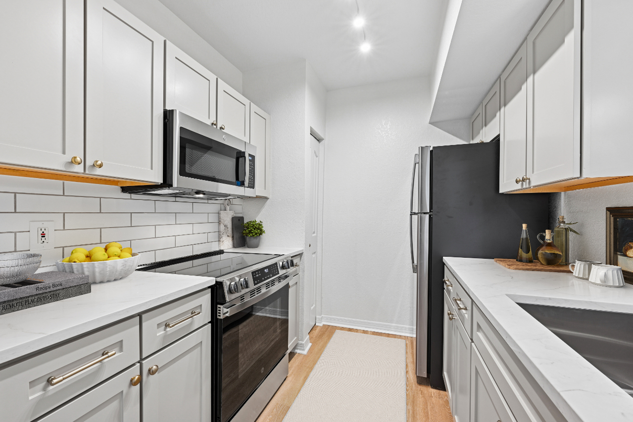 Modern kitchen with white cabinetry, stainless steel appliances, and a minimalist design.