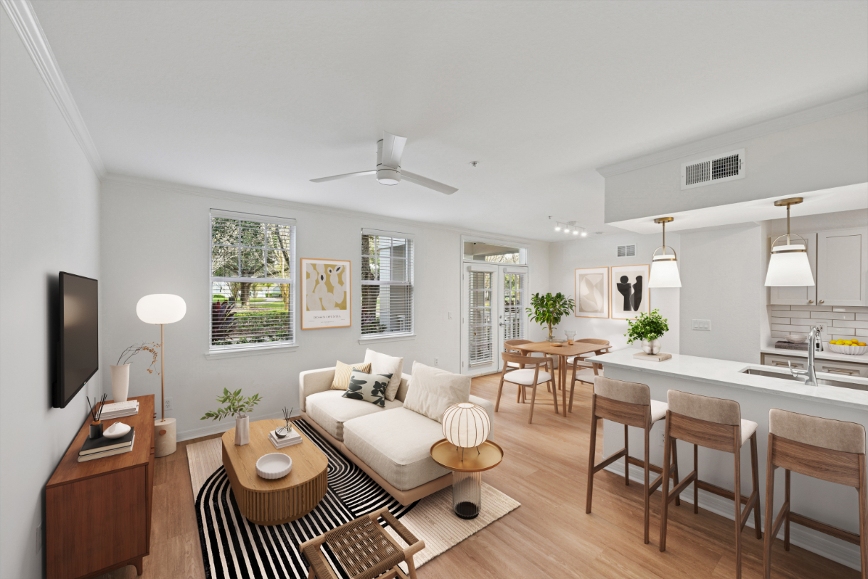 Modern living room and kitchen with light decor, wooden furniture, and large windows.