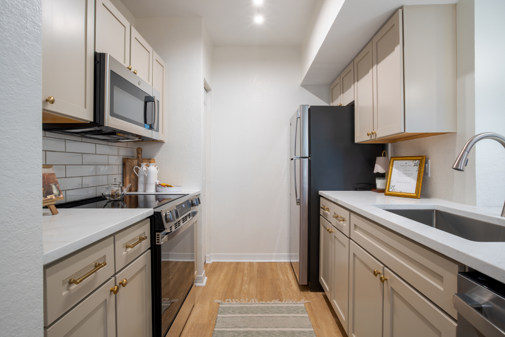 Modern kitchen with stainless steel appliances and white cabinetry.