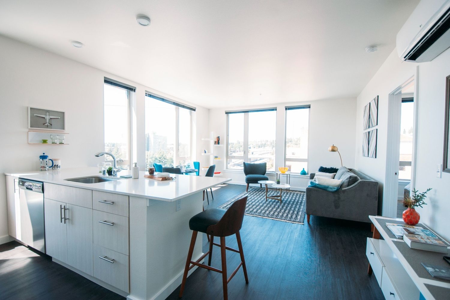 Bright, modern apartment with a kitchen, living area, and large windows.