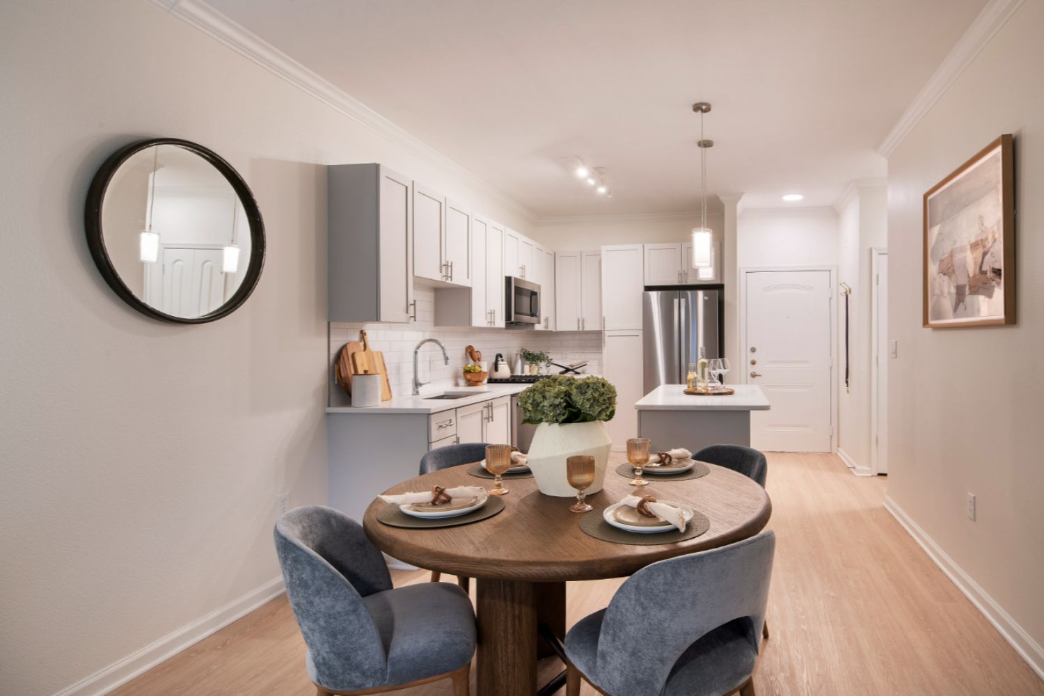 Kitchen with white stone counters and cabinets and dining table