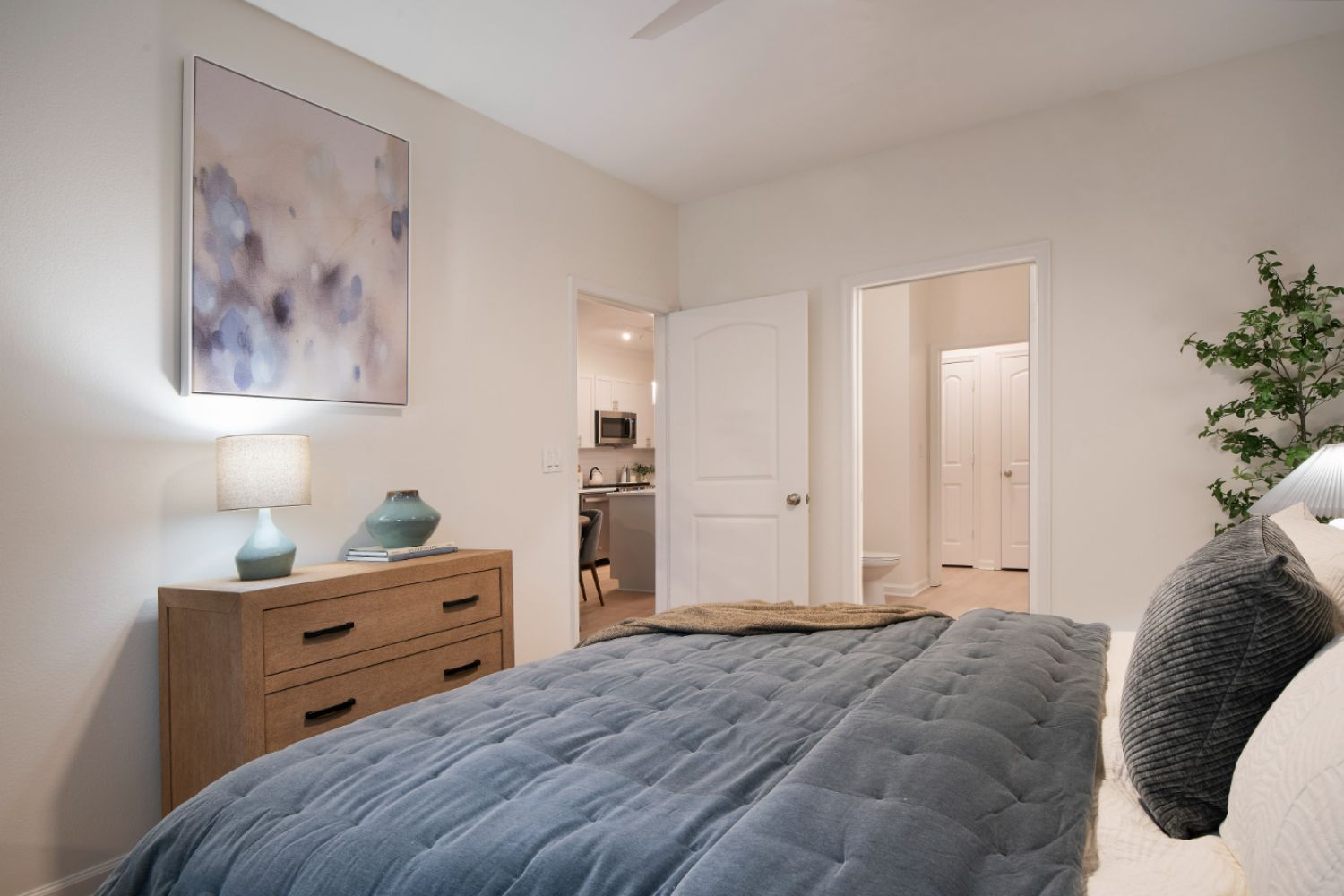 Bedroom with painting and tan dresser