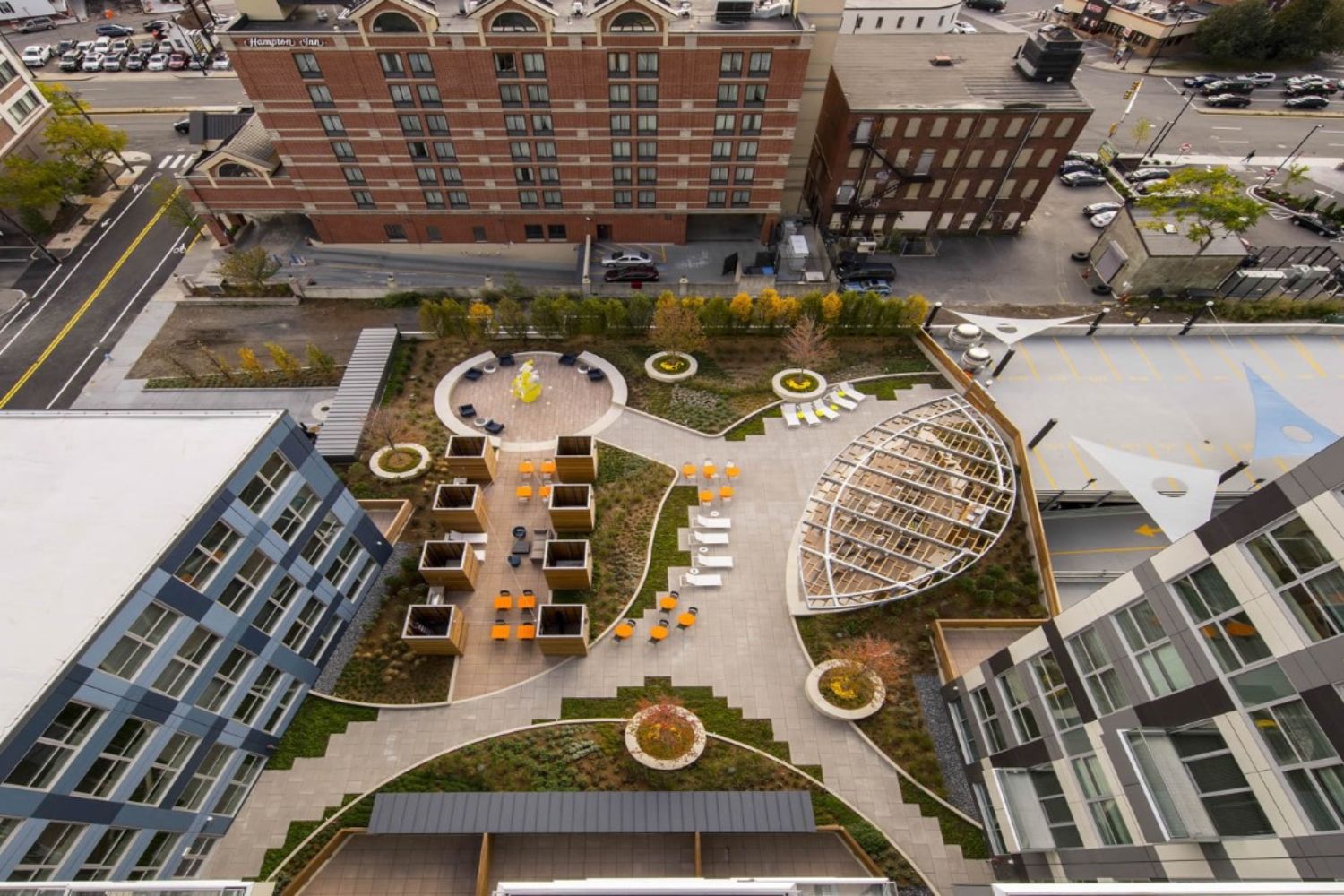 Aerial view of a landscaped rooftop with seating areas and greenery.