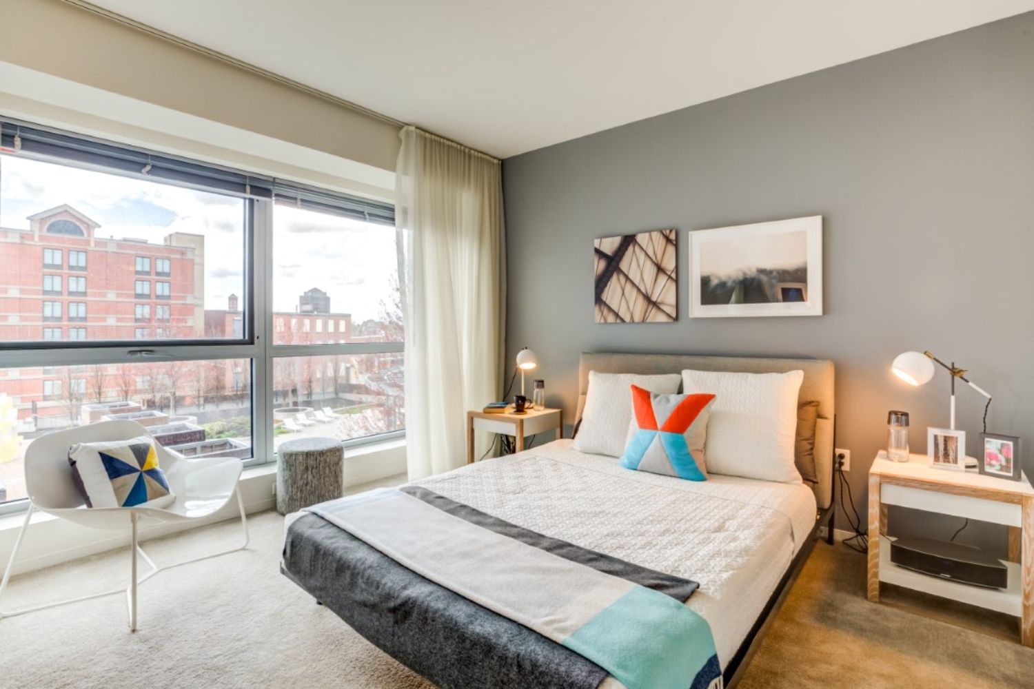 Modern bedroom with a large window, bed, and minimalist decor.