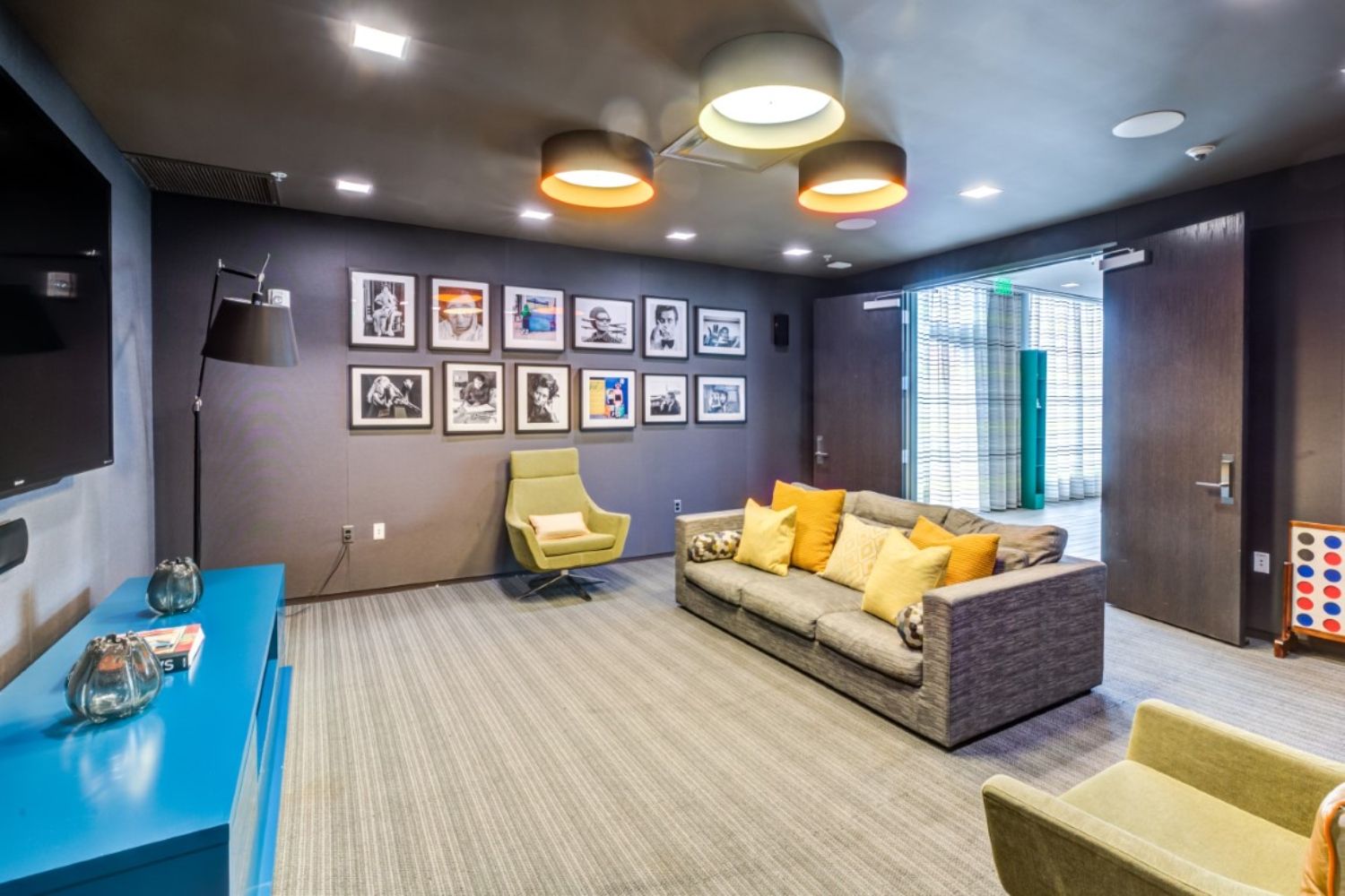 Modern lounge with a sofa, framed photos, and bright lighting.