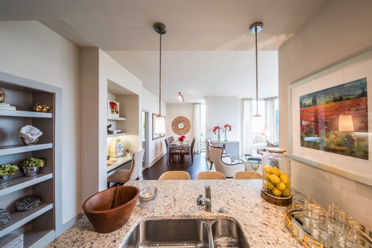 Modern kitchen with granite countertops and a view into a dining area and living room.