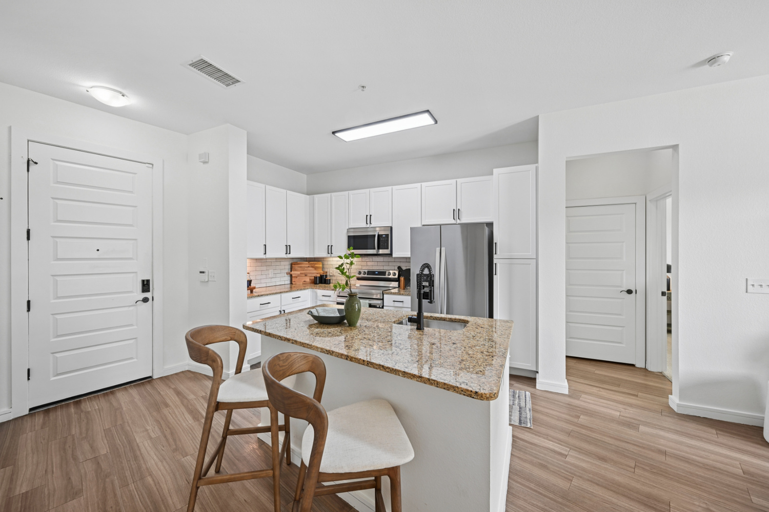 The kitchen island in an Aera RiNo apartment in Denver has granite countertops and bar seating.