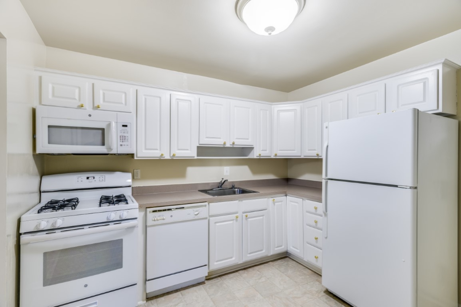 Clean, modern kitchen with white cabinets, appliances, and a neutral color scheme.