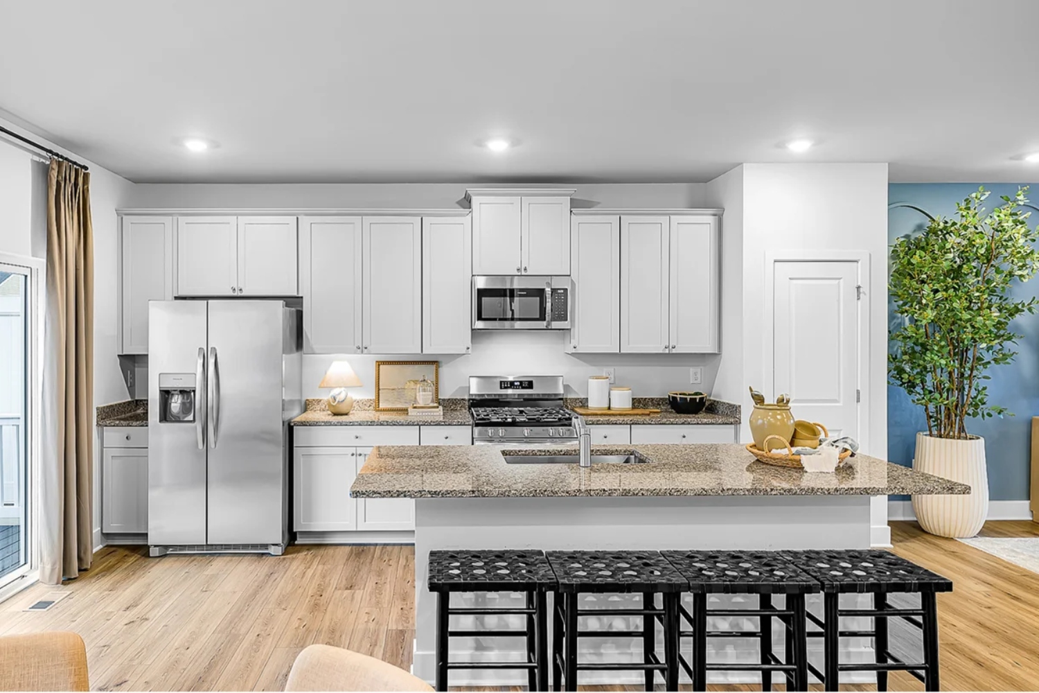 Modern kitchen with white cabinets, stainless steel appliances, and a central island.