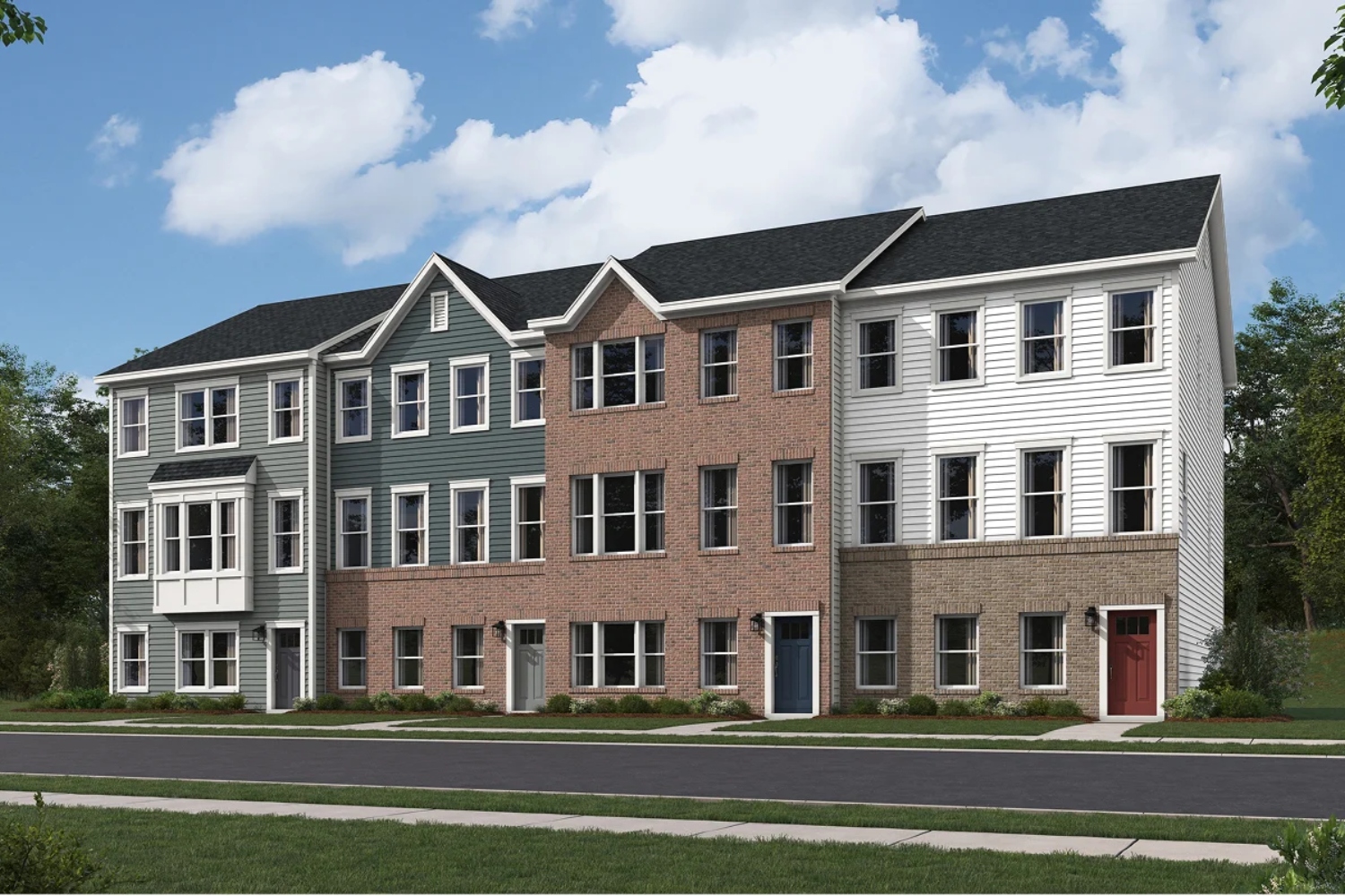 Row of three modern townhouses in varying colors under a blue sky with clouds.