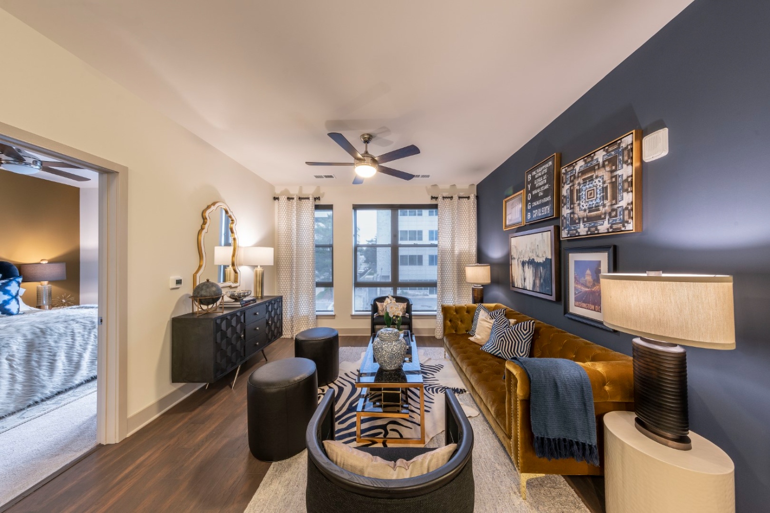 Modern living room with dark blue walls, stylish furniture, and artwork.