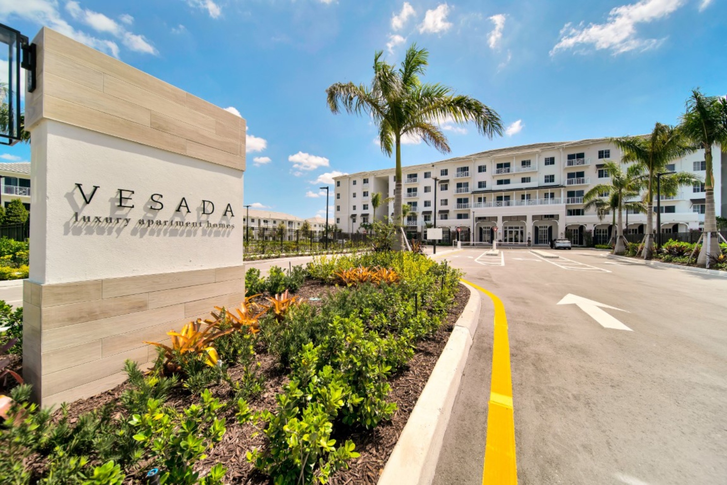 Vesada luxury hotel entrance with palm trees and a clear blue sky.