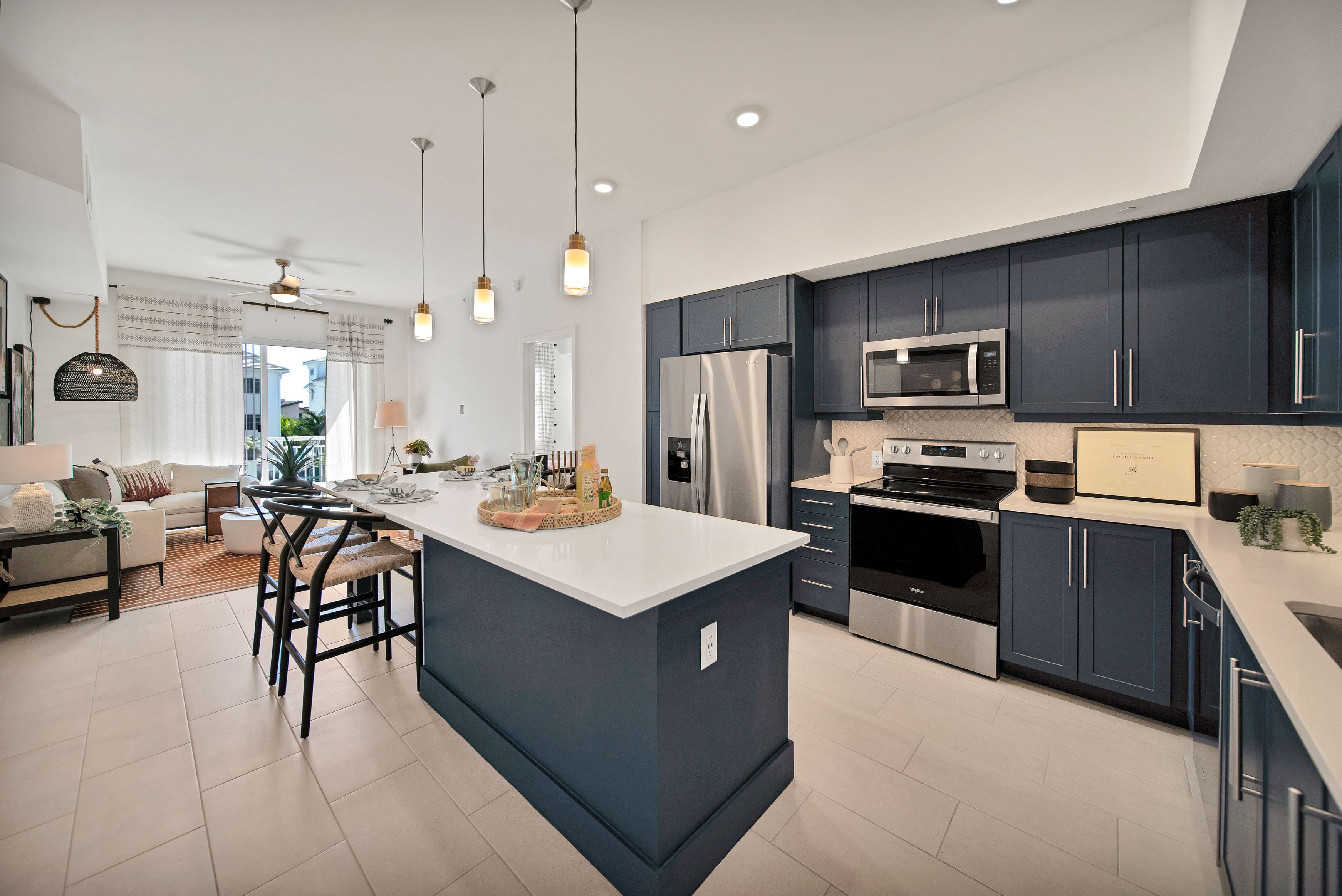 Modern kitchen with blue cabinets, white countertops, and stainless steel appliances.