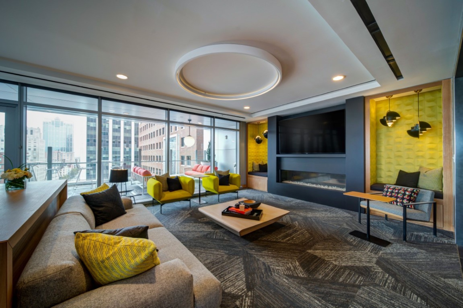 Modern living room with large windows, a cozy sofa, and vibrant yellow accents.