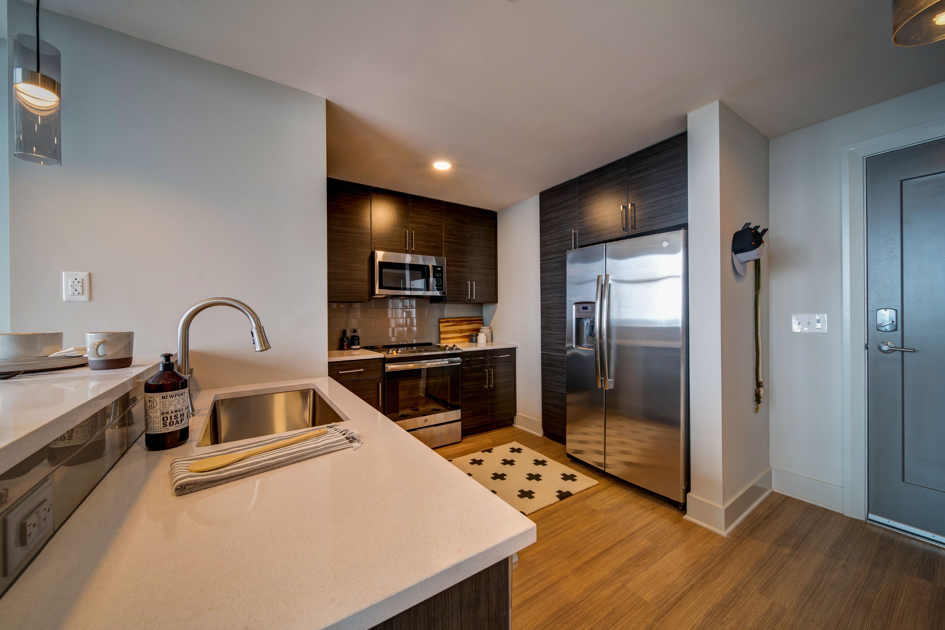 Modern kitchen with sleek cabinets, stainless steel appliances, and wooden flooring.