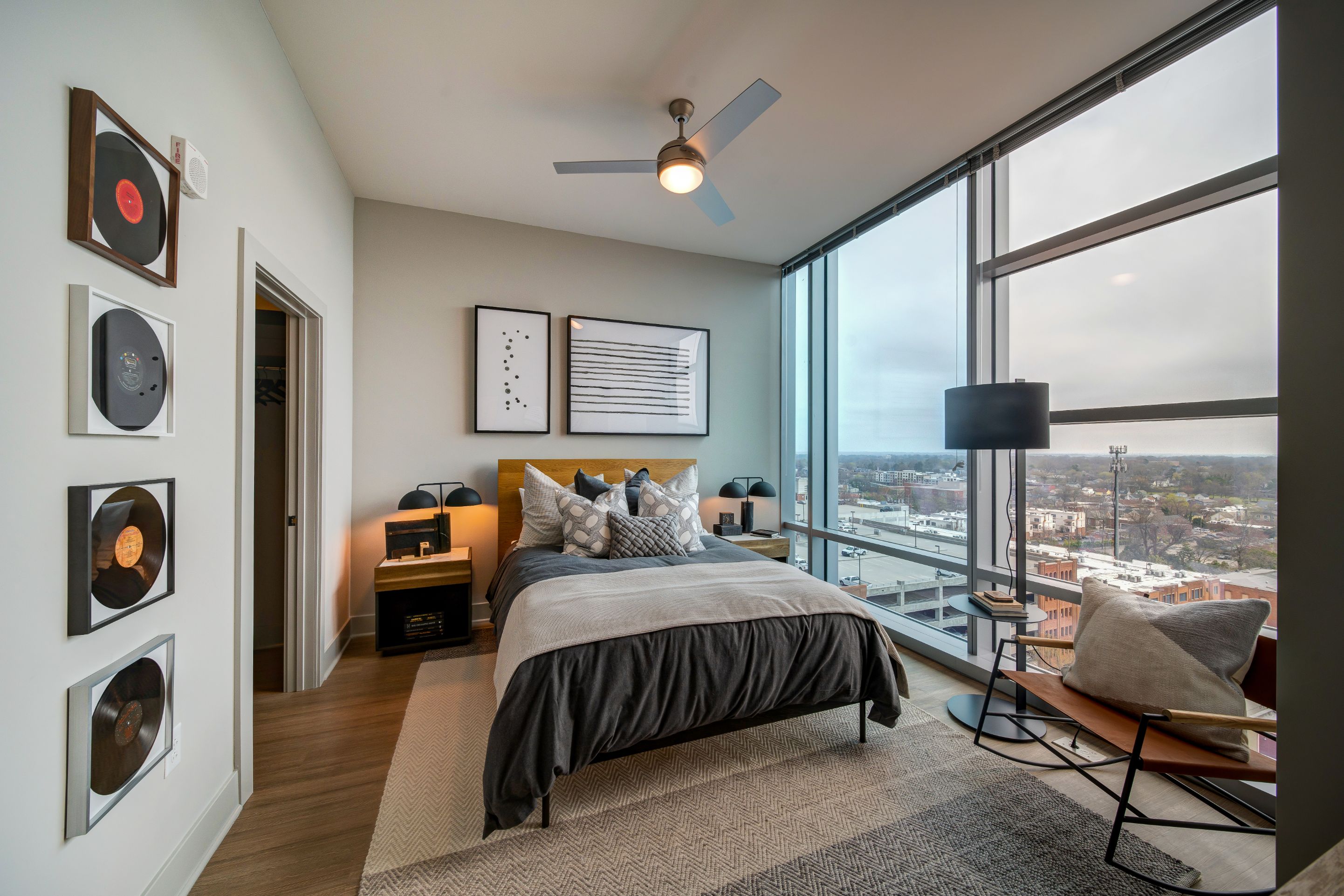 Modern bedroom with large windows, a bed, and minimalist decor.