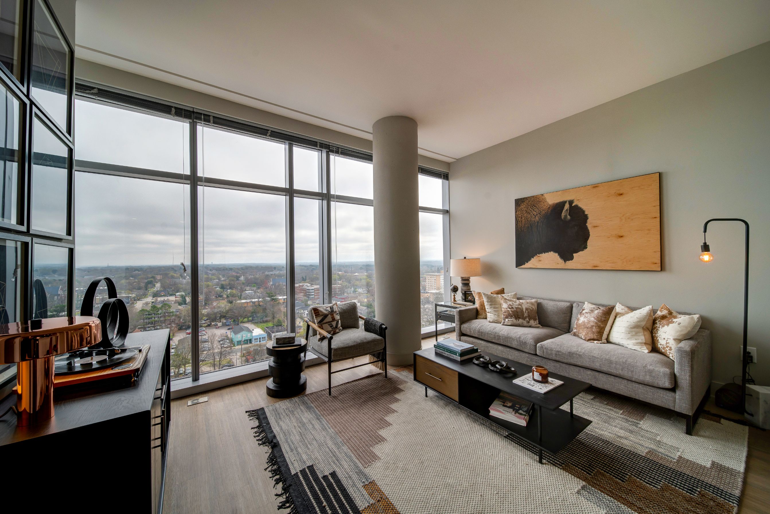 Modern living room with large windows, stylish furniture, and a scenic view.