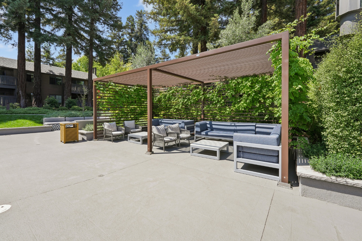 Poolside cabana with seating and nearby swimming pool at Old Orchard Apartments