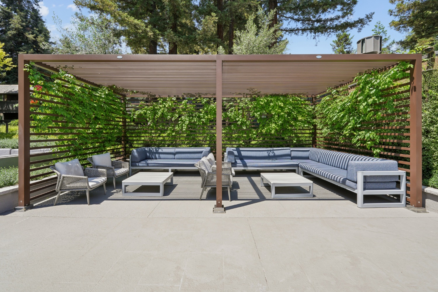 Covered outdoor cabana with seating and lounge furniture at Old Orchard Apartments
