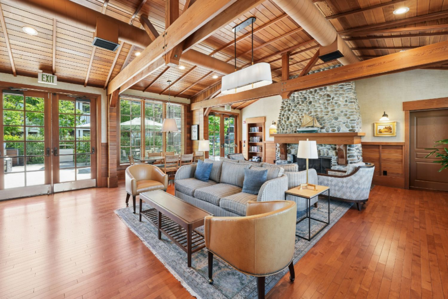 Clubhouse interior with wood finishes, couches, chairs, and multiple seating areas
