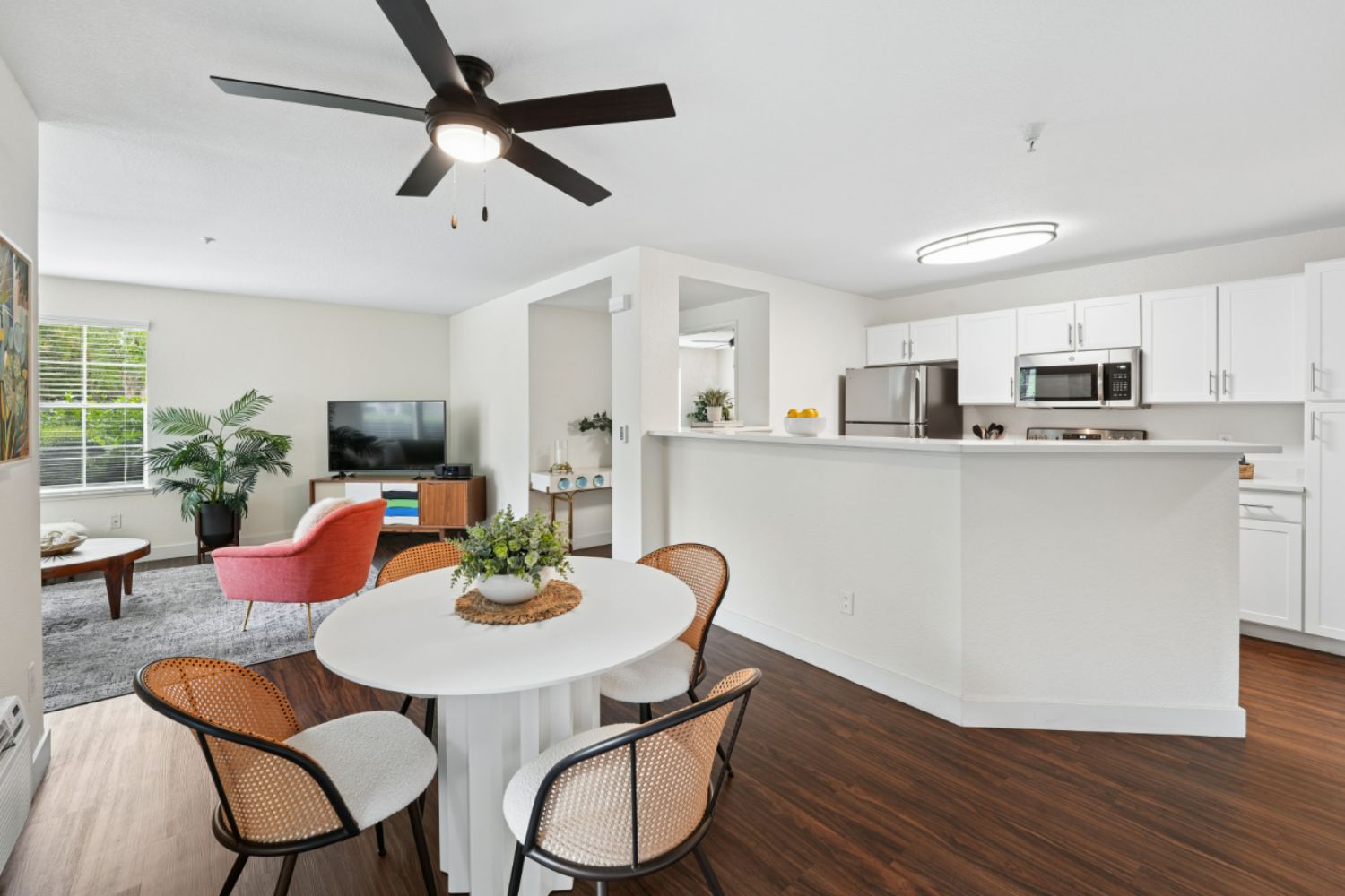 Open-concept living room and kitchen with island seating, modern finishes, and natural light