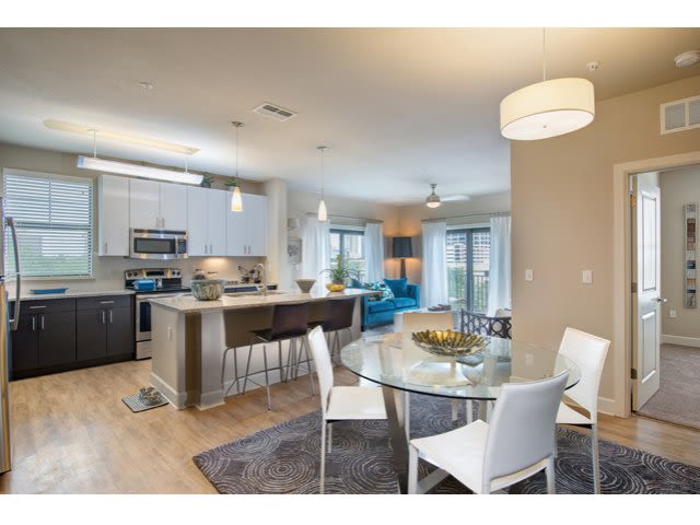 Modern kitchen and dining area with a glass table and contemporary furnishings.