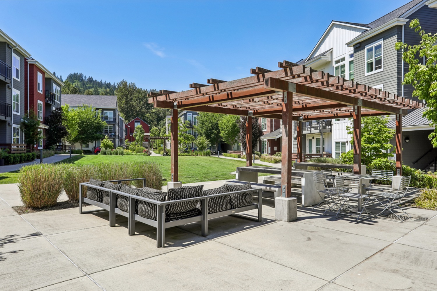 Outdoor seating area at Anthology Apartments with a wooden pergola.