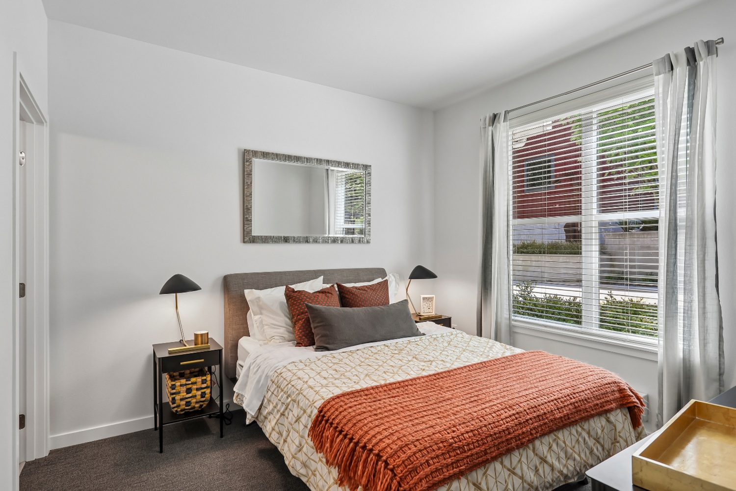 Cozy bedroom in Anthology Apartments with a bed and large window for natural light.