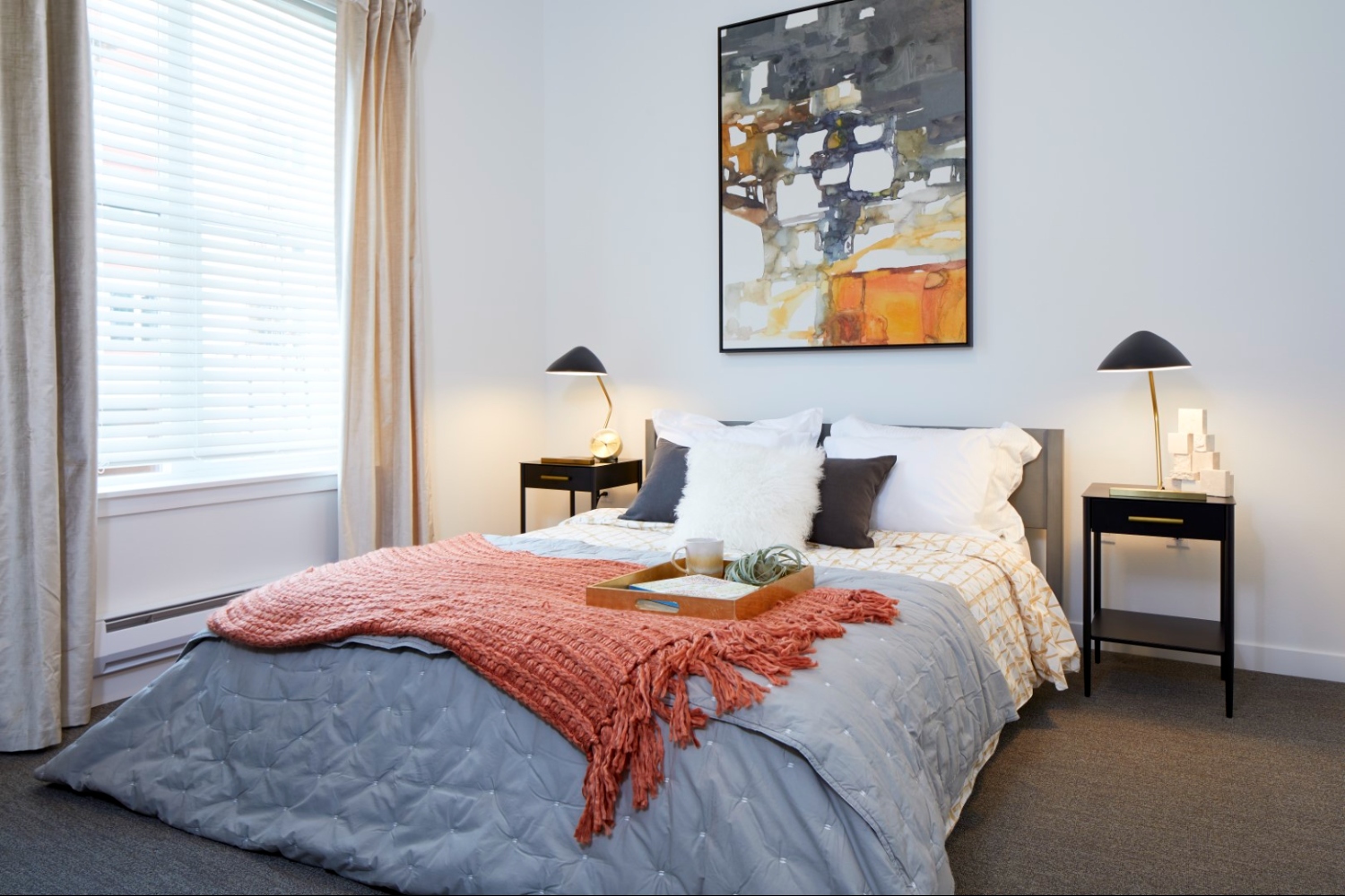 Contemporary apartment bedroom with large windows, neutral tones, and city views in Denver
