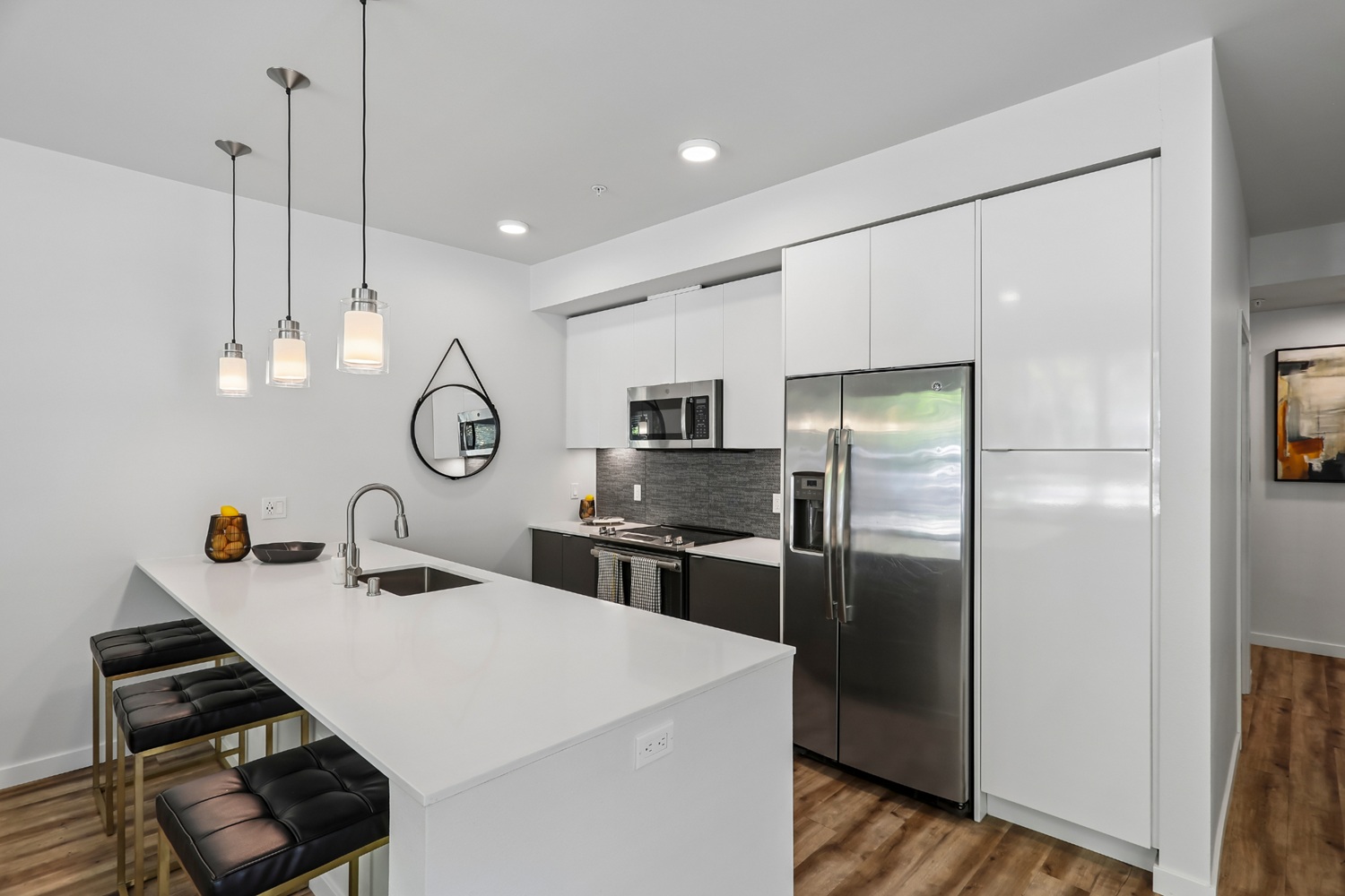 Modern kitchen at Anthology Apartments with sleek cabinetry and bar seating.