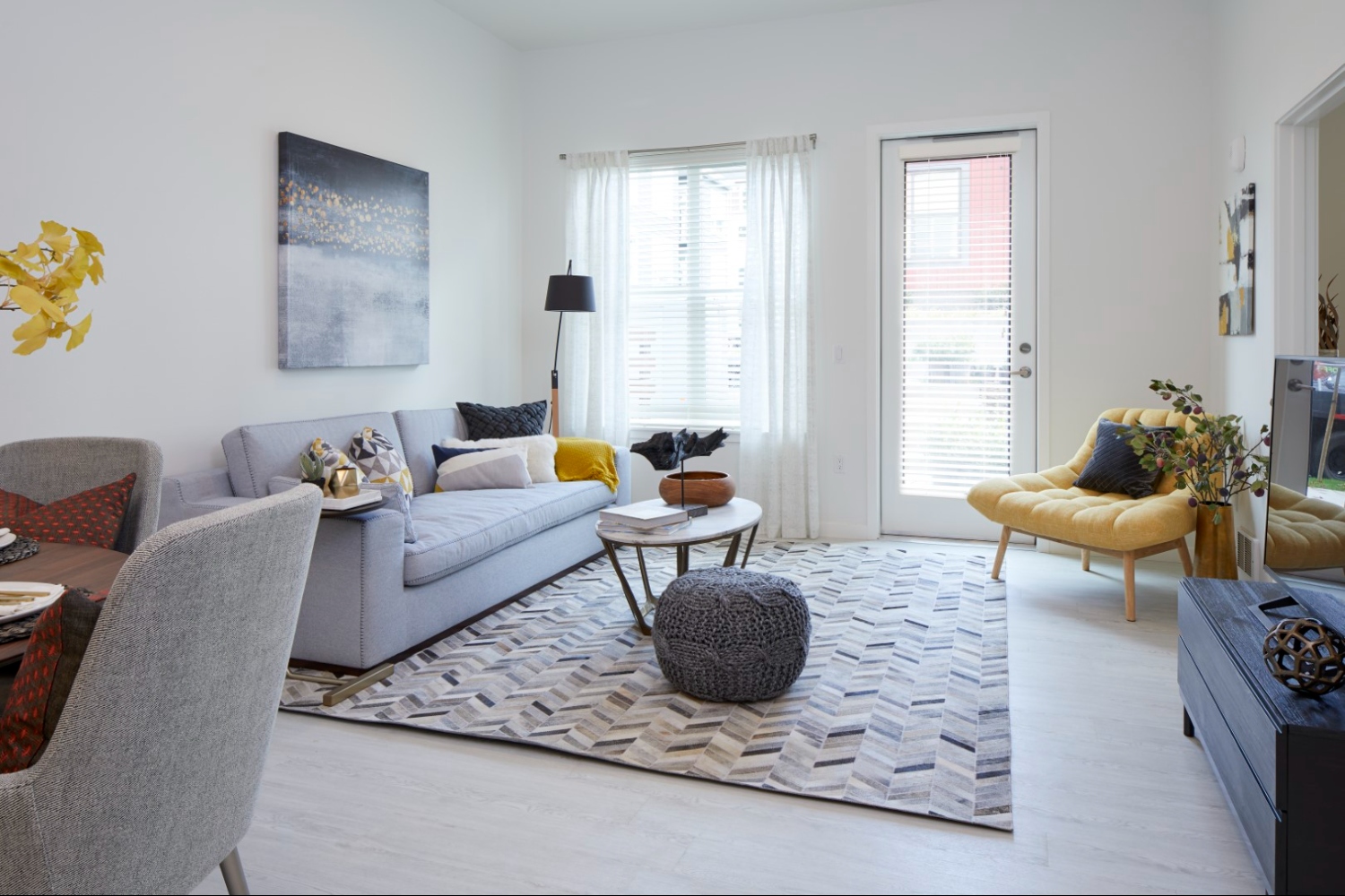 Luxury apartment living room with floor-to-ceiling windows, modern furniture, and natural light in Denver apartment