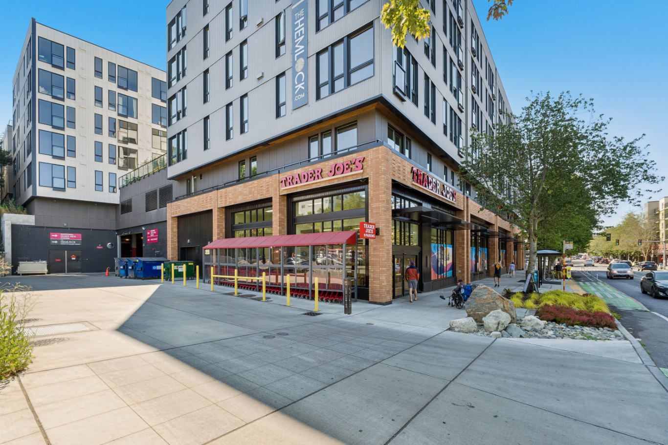 Corner view of a modern building with a cafe and outdoor seating.