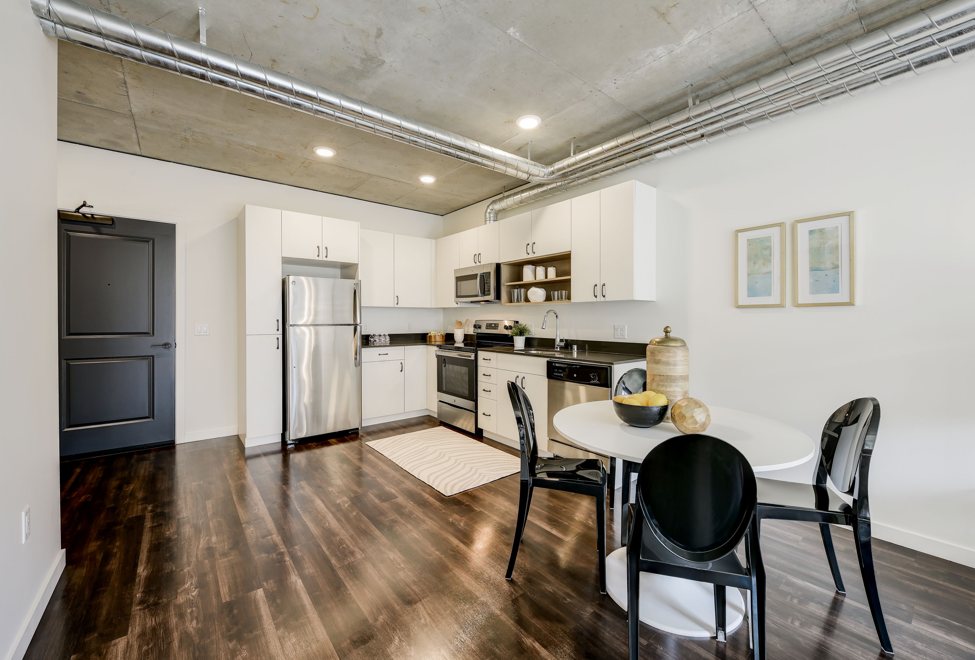 Modern kitchen with stainless steel appliances and dining table.