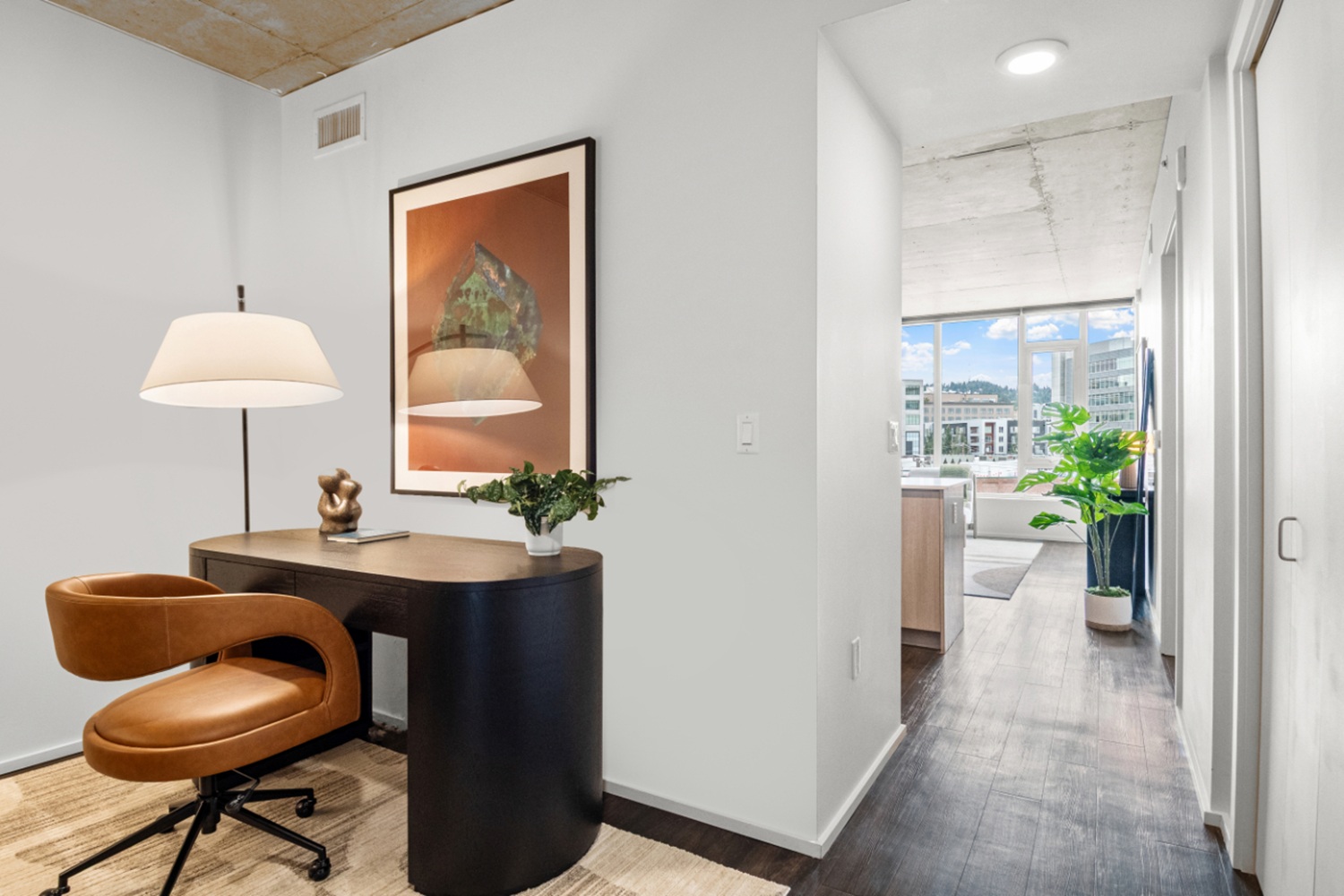 Apartment hallway and office nook at NV Apartments with workspace setup and open-concept layout.