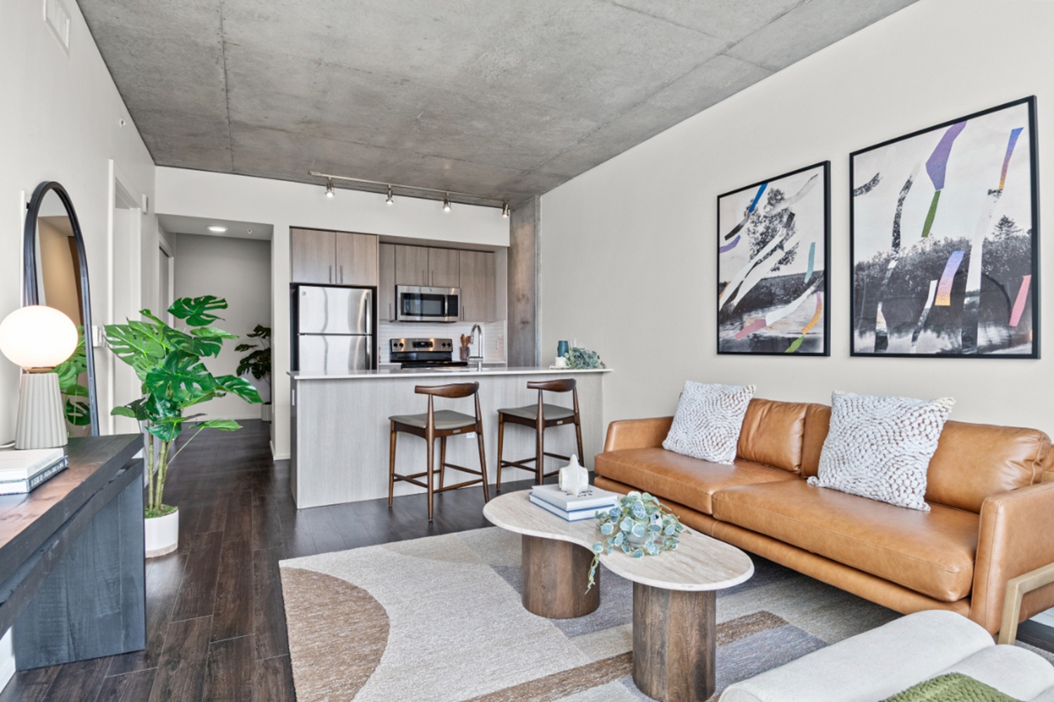 Apartment living room at NV Apartments with oversized windows, modern furniture, and Portland skyline views.