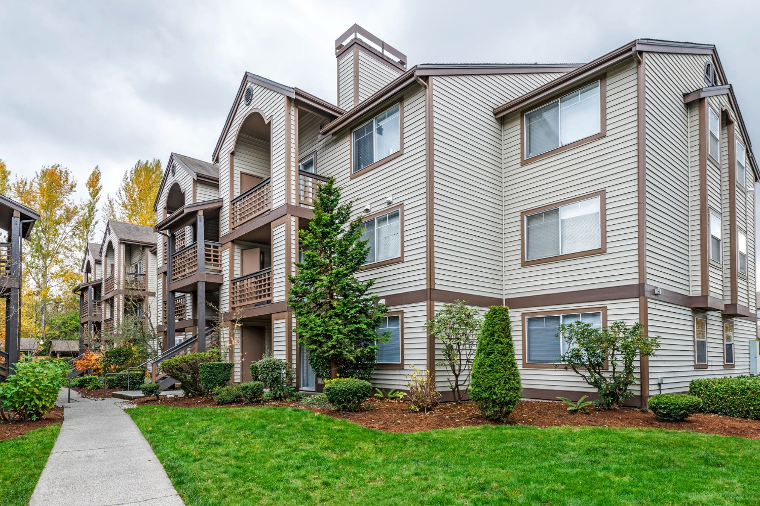 Olin Fields Apartments exterior surrounded by greenery and walkways.
