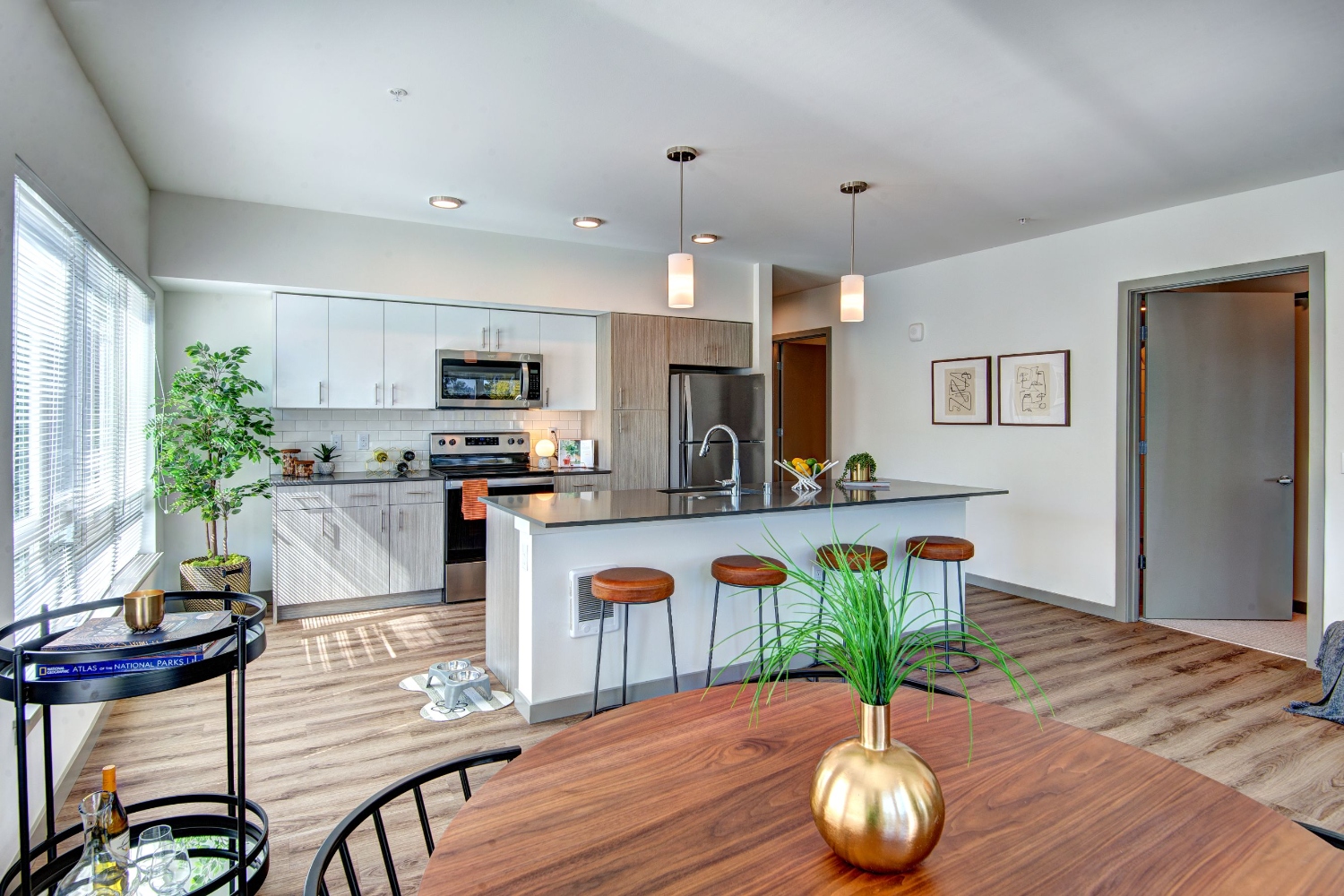 Modern kitchen and dining area with sleek decor and natural light.