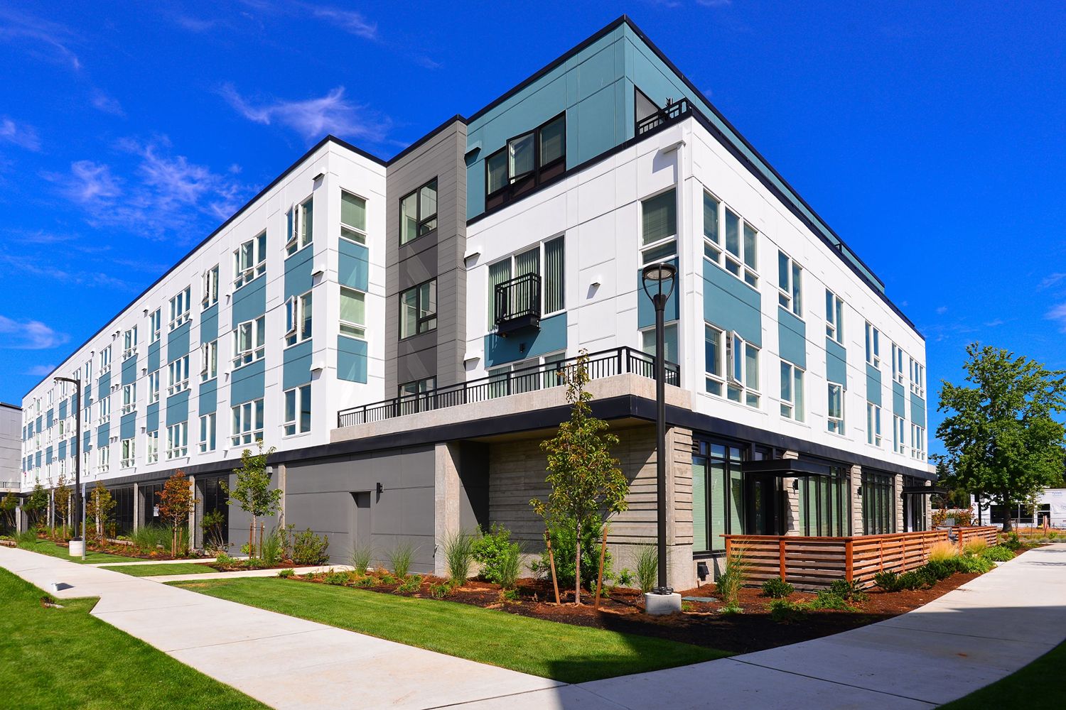 Midtown 64 apartment building with landscaped grounds under a blue sky.