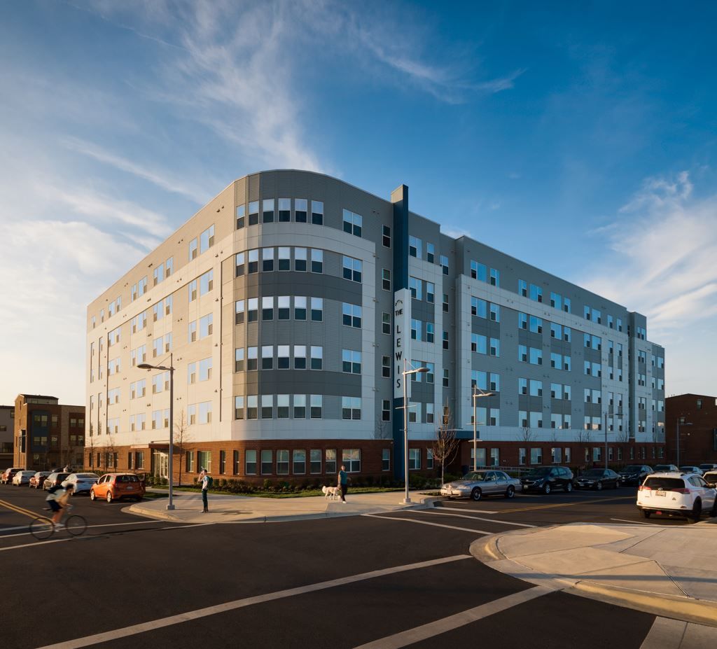 Modern multi-story building with large windows against a blue sky.